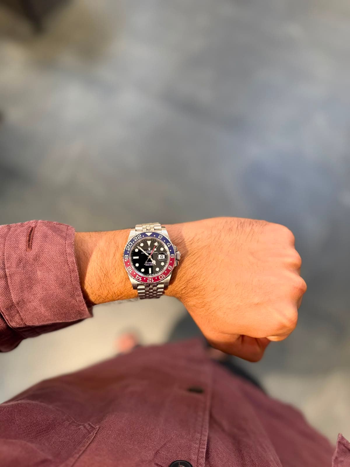 Rolex GMT-Master Pepsi against a textured gray wall