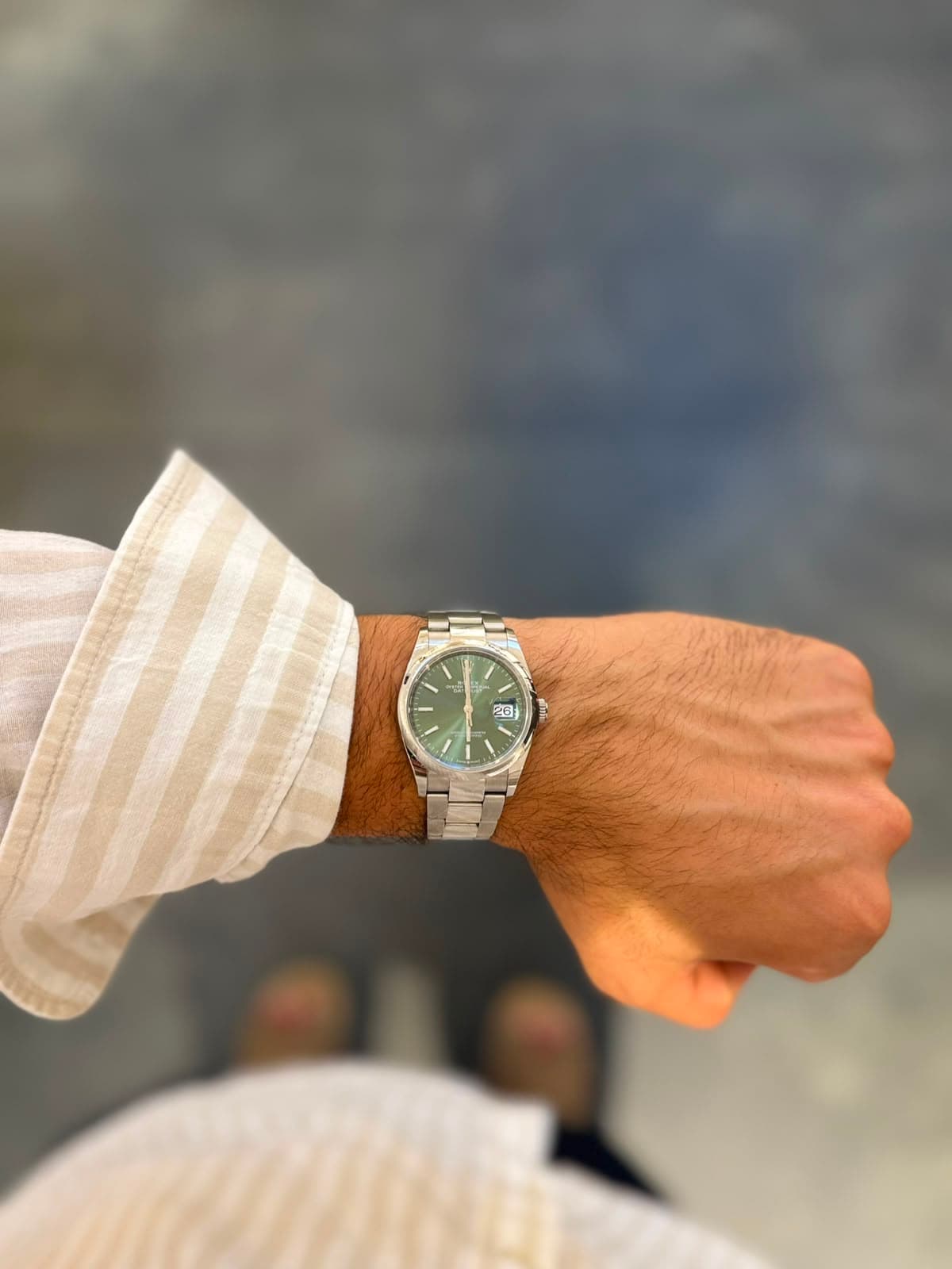 Rolex Datejust green dial against a textured wall