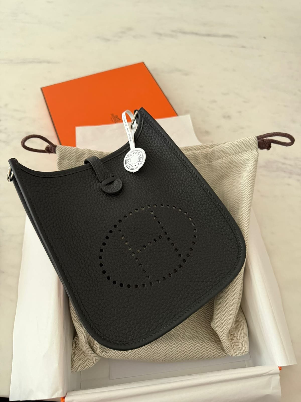 Hermès Evelyne crossbody bag presented in its box with dust bags