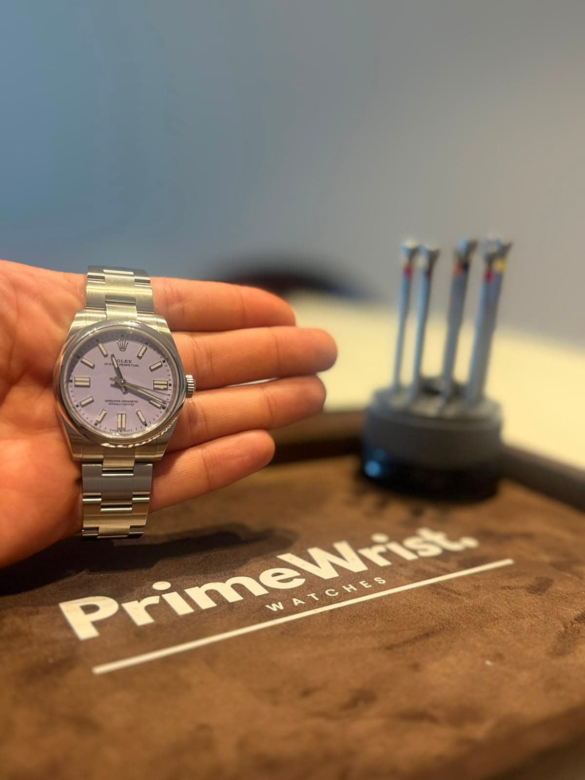 Watches presented alongside authentication and winding tools on a branded suede tray